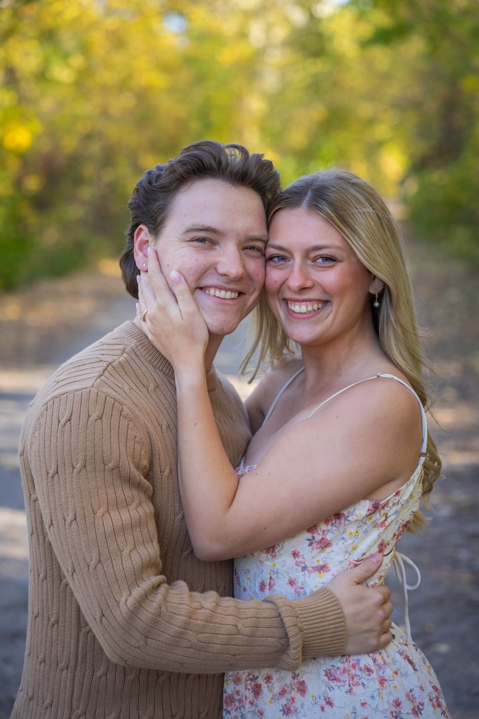 Couple embracing in autumn light, her hand on his cheek
